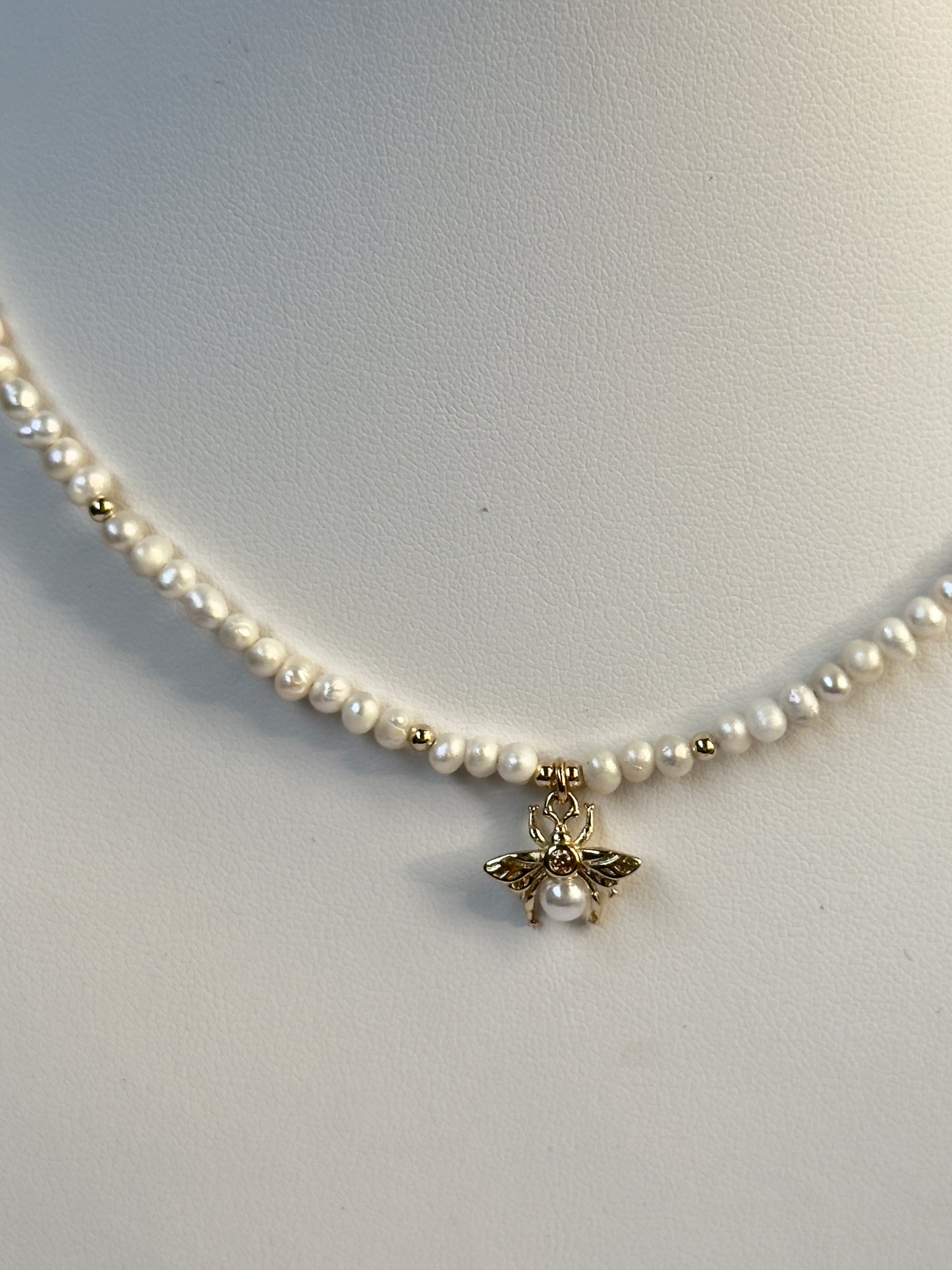 Collier de perles blanches avec pendentif abeille