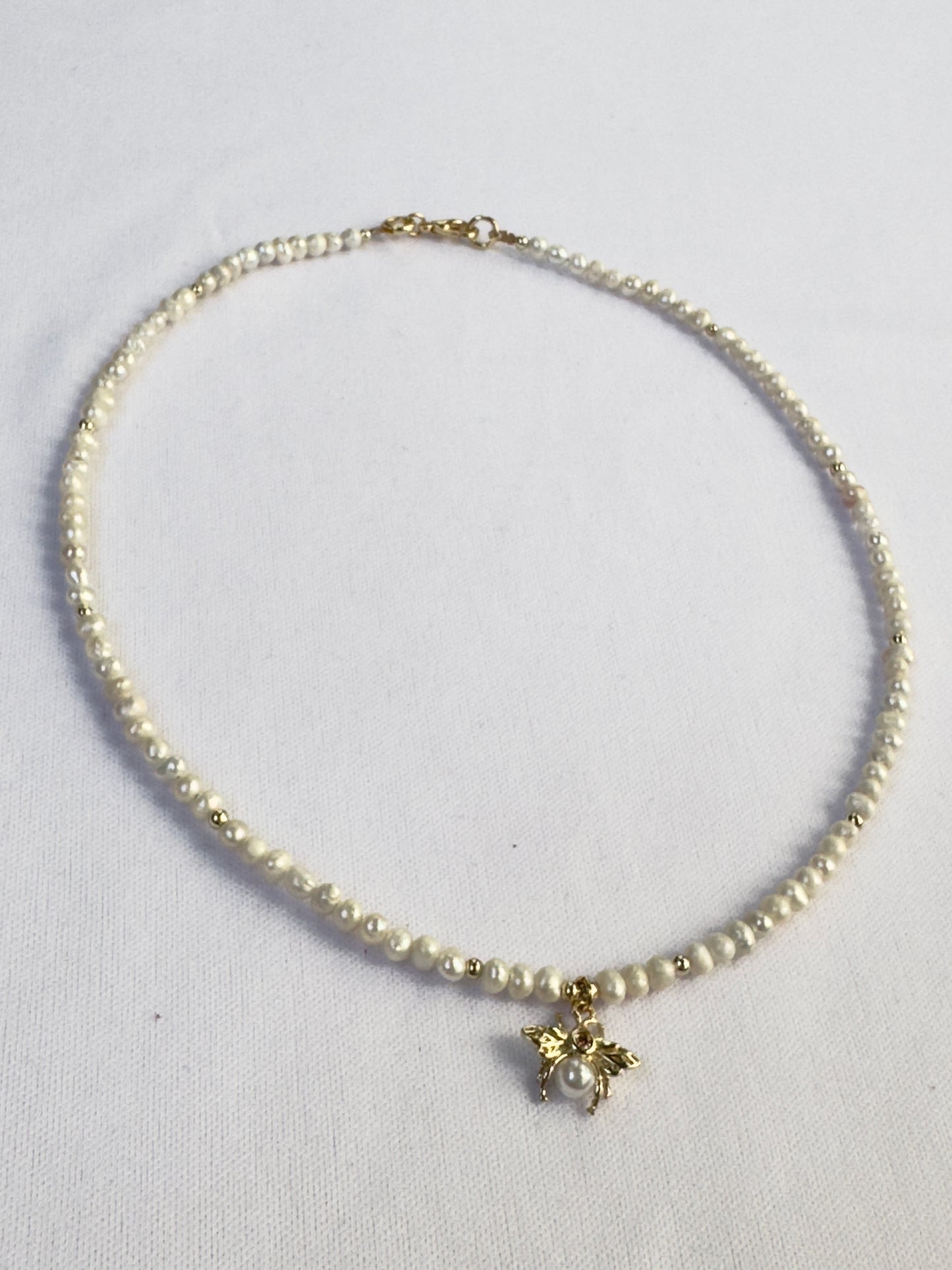 Collier de perles blanches avec pendentif abeille