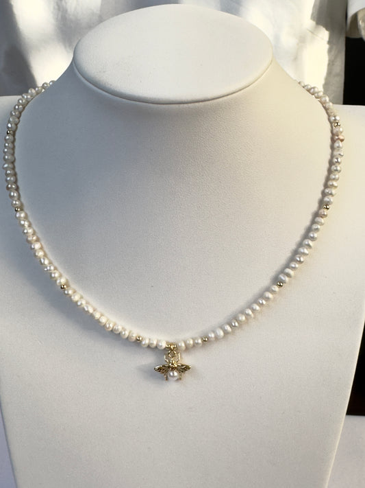 Collier de perles blanches avec pendentif abeille